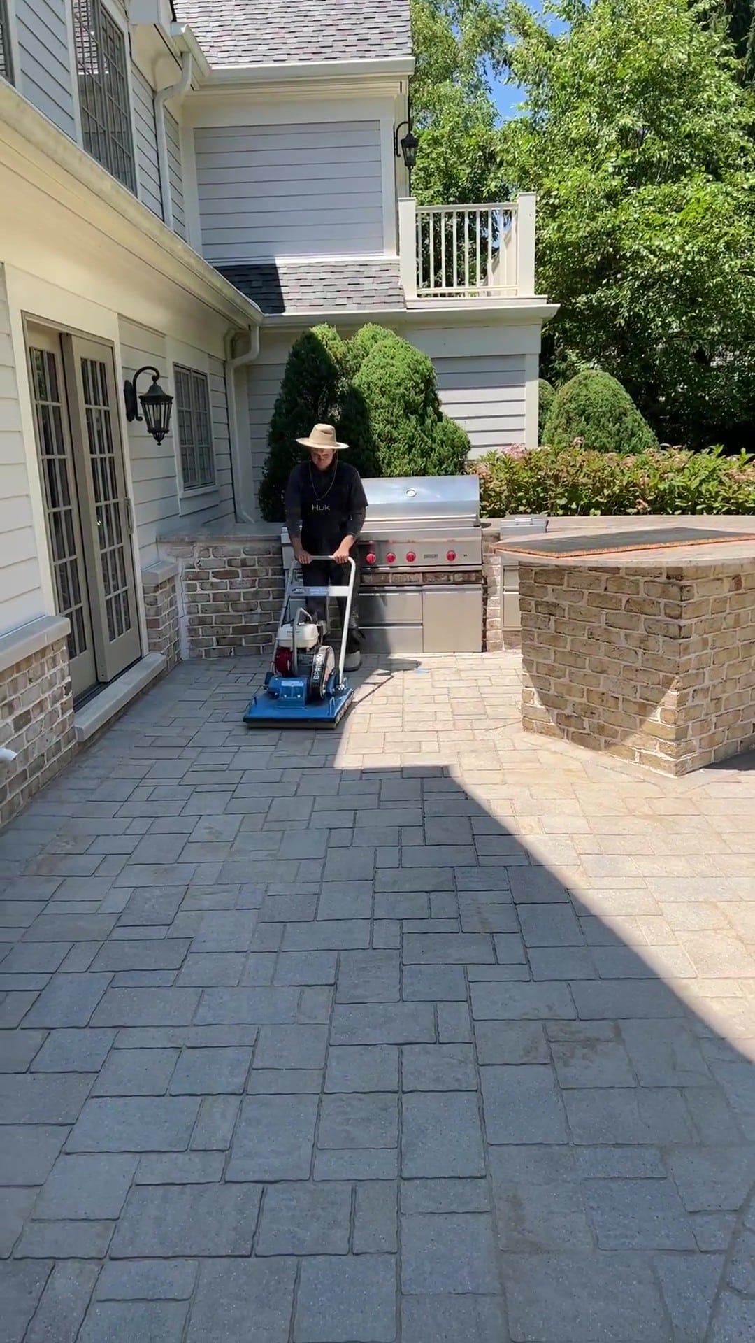 Matthew operating the Bartell Global BPR1080H vibratory paver roller on a Nassau County patio restoration — Pressure Wash Long Island