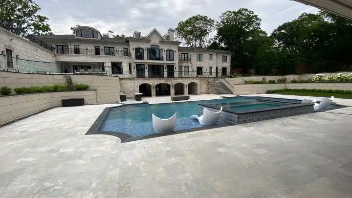 Sealed travertine pool deck on a luxury North Shore Long Island estate — professional paver restoration by Pressure Wash Long Island