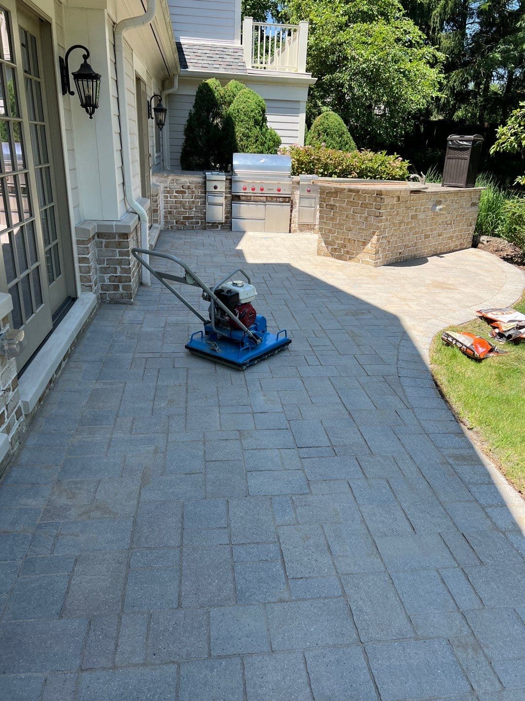 Bartell Global BPR1080H vibratory paver roller on a residential patio job — Pressure Wash Long Island uses professional compaction equipment for polymeric sand installation in Nassau County