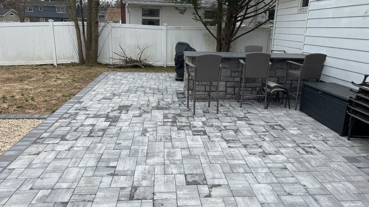 Damp paver patio with uneven moisture patches — Nassau County patio not ready to seal after winter — Pressure Wash Long Island