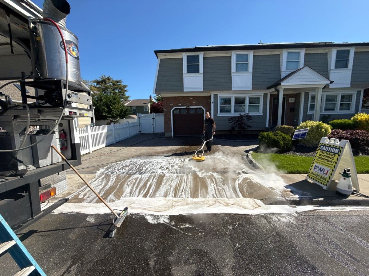 Kevin stripping failed paver sealer from a residential driveway using a surface cleaner — paver restoration by Pressure Wash Long Island, Nassau County NY