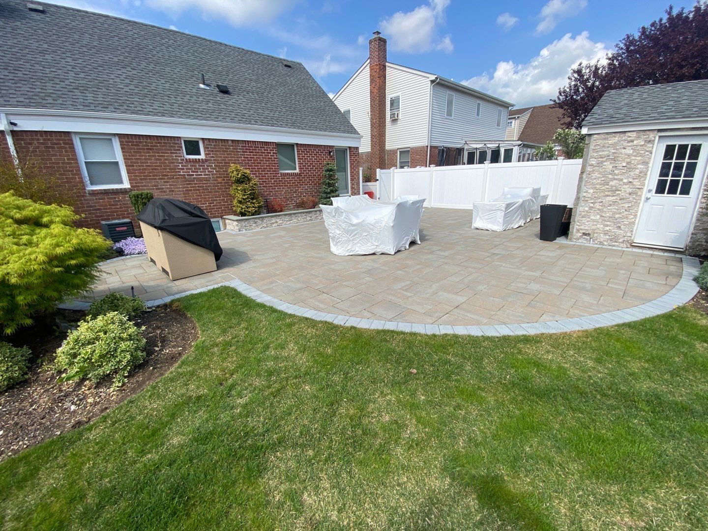 Brick Colonial with paver patio and vinyl fence — residential exterior cleaning Mineola NY by Pressure Wash Long Island